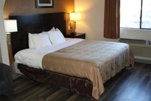 ein großes Bett in einem Hotelzimmer mit zwei Lampen in der Unterkunft Quality Inn & Suites Wichita Falls I-44 in Wichita Falls