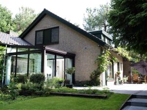 VenhorstにあるStunning villa in Venhorst with saunaの大きなガラス窓と庭のある家