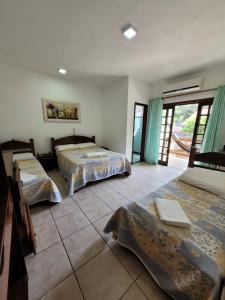 a bedroom with two beds and a tiled floor at Pousada Leão do Mar in Abraão