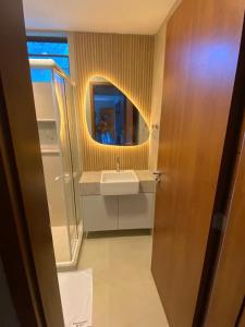 ein Badezimmer mit Waschbecken und Spiegel in der Unterkunft Flat térreo luxo 2qts Carneiros ao lado da igrejinha in Tamandaré