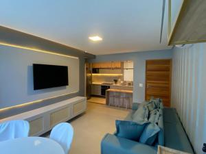 ein Wohnzimmer mit Couch und Flachbildfernseher in der Unterkunft Flat térreo luxo 2qts Carneiros ao lado da igrejinha in Tamandaré