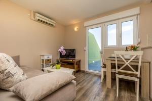 uma sala de estar com um sofá, uma mesa e uma secretária em Rooms with a parking space Mali Losinj (Losinj) - 9681 em Mali Lošinj