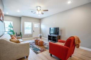 uma sala de estar com 2 cadeiras e uma televisão de ecrã plano em Relax, Rejuvenate, Retreat in Gated Community near Greater Heights em Houston
