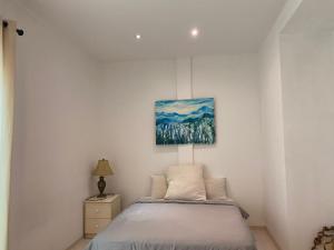 1 dormitorio con 1 cama y una pintura en la pared en Wesberly Apartments, en Kuching
