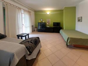 a hotel room with two beds and a television at Apartments by the sea Duga Luka - Prtlog, Labin - 3025 in Labin