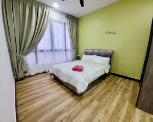 a bedroom with a bed with two red shoes on it at Bali Residence Impian Raudah in Melaka