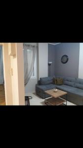 a living room with a blue couch and a table at Piraeus historical center in Piraeus