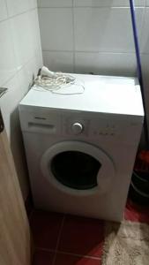 a white washing machine in a corner of a bathroom at Piraeus historical center in Piraeus