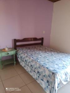 a small bedroom with a bed and a table at Residencial família Milani 100 metros do mar Torres in Torres