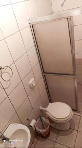 a bathroom with a toilet and a shower stall at Residencial família Milani 100 metros do mar Torres in Torres