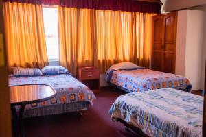 a hotel room with two beds and a window at Unión Plaza Hotel in Cochabamba