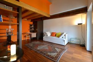 un soggiorno con divano bianco e tavolo di Heart Milan Apartments Navigli a Milano