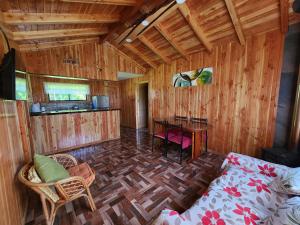 a room with a bed and a table in a room at Cabaña Nuevo Amanecer in San José de la Mariquina
