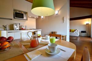 una cucina e una sala da pranzo con tavolo in legno di Heart Milan Apartments Navigli a Milano