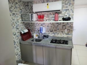 a small kitchen with a sink and a stove at Laguna Beach Flat in Porto De Galinhas