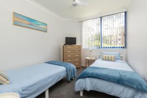 a bedroom with two beds and a window at Heritage 103 in Tuncurry