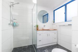 a white bathroom with a sink and a mirror at Heritage 103 in Tuncurry +6 photos