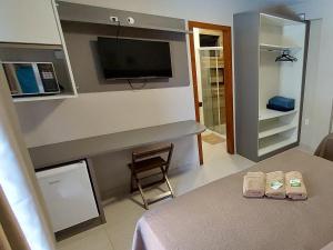 Habitación con cama y TV. en Pousada Casa Da Praia, en Florianópolis