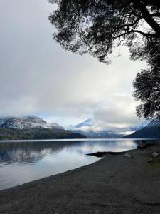 vistas a un lago con montañas en el fondo en Departamentos Patagonia calle Rivadavia en El Bolsón