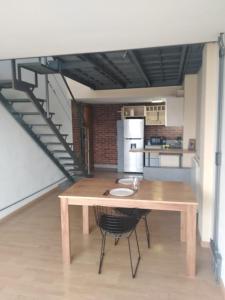 una cocina con una mesa de madera y una escalera en Duplex zona exclusiva Caballito en Buenos Aires