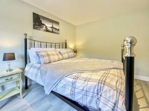 a bedroom with a bed and a table with a lamp at The Home Stables in Southwick