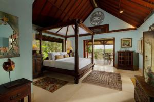 a bedroom with a canopy bed in a room at Villa Inka Ubud by Nakula in Ubud