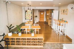 a room with wooden tables and shelves with potted plants at Pakping Hostel in Chiang Mai