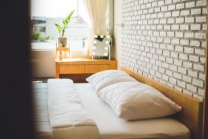 uma cama num quarto com uma parede de tijolos em Pakping Hostel em Chiang Mai