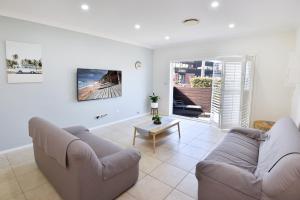 a living room with two couches and a table at Point Bulli in Bulli