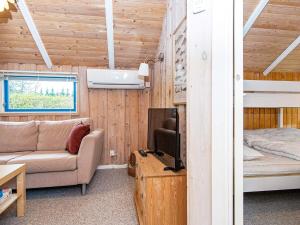ein Wohnzimmer mit einem Sofa, einem TV und einem Bett in der Unterkunft Holiday home Fårvang XIX in Fårvang