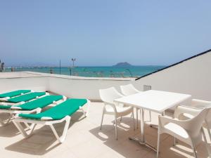 科拉雷侯的住宿－Resort, Corralejo，一个带白色桌椅的庭院和海滩