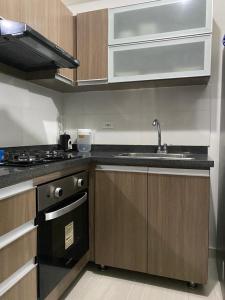 cocina con fregadero y fogones en Barranquilla Gran Apartamento, en Puerto Colombia