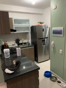 cocina con nevera de acero inoxidable y encimera en Barranquilla Gran Apartamento, en Puerto Colombia