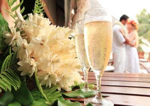 dos copas de champán sentadas en una mesa con flores en Le Tikehau by Pearl Resorts, en Tikehau