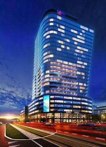 een hoog gebouw met auto's ervoor bij Hotel Hanza Tower 5 Stars in Szczecin