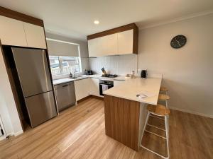 a kitchen with a counter top and a refrigerator at Cosy Self Contained 2 Bedroom Townhouse in Hamilton