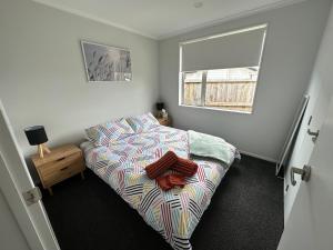 a small bedroom with a bed and a window at Cosy Self Contained 2 Bedroom Townhouse in Hamilton
