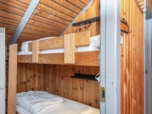 FårvangにあるHoliday Home Mågevej VIIIの二段ベッド2組が備わる木造の部屋です。