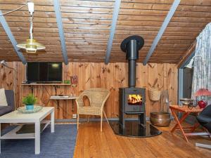 een woonkamer met een houtkachel. bij Holiday Home Mågevej VIII in Fårvang