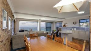 a kitchen and living room with a table and chairs at Lonerock Unit 2 in Yamba
