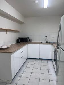 a kitchen with a sink, stove, and refrigerator at Condor Ocean View Apartments Surfers Paradise in Gold Coast