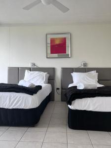 a hotel room with two beds and a mirror at Condor Ocean View Apartments Surfers Paradise in Gold Coast