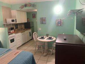uma cozinha com uma pequena mesa e uma cozinha com uma cama em Michaels Surfside Cabanas em Clearwater Beach