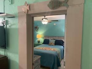 1 dormitorio con cama y espejo en Michaels Surfside Cabanas, en Clearwater Beach