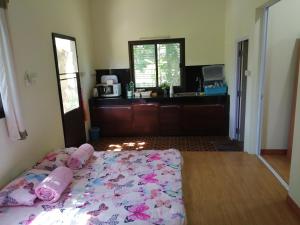 1 dormitorio con 1 cama con colcha rosa en Wasuthan Garden House en Nong Khai