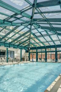 une piscine intérieure avec un toit en verre dans l'établissement Résidence Pierre & Vacances Centre, à La Rochelle