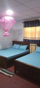 Cette chambre dispose de deux lits et d'un plafond rose. dans l'établissement Impress Holiday Home, à Anurâdhapura
