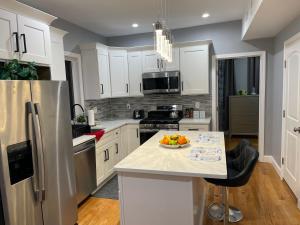 a kitchen with a refrigerator and a bowl of fruit on a counter at Brand New Luxury Rooms near downtown Boston in Boston