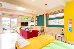 een slaapkamer met een geel bed en een woonkamer bij ビタミンハウス伊豆高原 - vitaminhouse IZUKOGEN in Ito