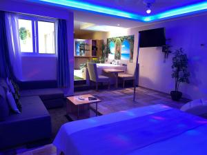 Sosua Inn Hotel في سوسْوا: غرفة معيشة أرجوانية مع أريكة وطاولة